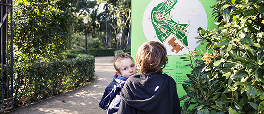 Dos menors mirant el mapa dels Jardins de Laribal