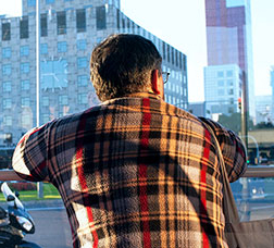 Home d'esquenes mirant per la finestra d'un autobús