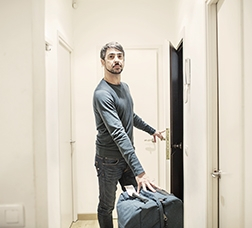 Man in an apartment with a suitcase  