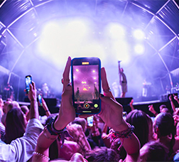A person recording a concert with their mobile phone.